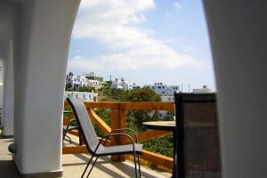 uma varanda com uma mesa, uma cadeira e uma vista em Amarain Mykonos em Agios Stefanos