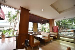 a restaurant with a table and chairs and a window at Bangkok City Suite in Bangkok