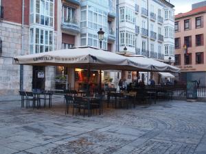 a patio with tables and chairs and umbrellas at Minaya in Burgos