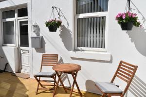 2 Stühle und ein Tisch vor einem Haus in der Unterkunft Adelaide Apartments in Blackpool