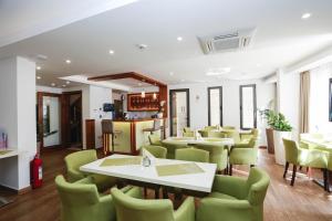 a dining room with tables and green chairs at Arka Budva in Budva