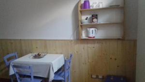 a table with a white table cloth and blue chairs at B&B Artemia in Trento