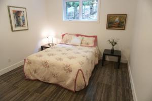 a bedroom with a bed and two tables and a window at Club Loisirs Nautiques Quebec in Lac-aux-Sables