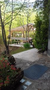 a picnic shelter with a bench in a garden at B&B Artemia in Trento