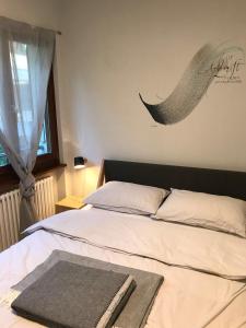 een slaapkamer met een bed met een deken erop bij Al Grottino in Gambarogno