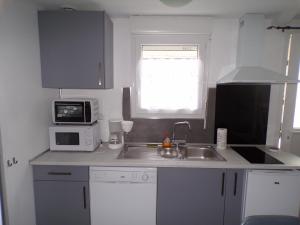 a small kitchen with a sink and a microwave at Studio Violine in Berck-sur-Mer