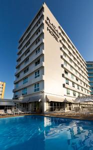 un hotel con piscina frente a él en Plaza Blumenau Hotel, en Blumenau