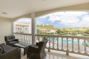 a balcony with chairs and a view of the pool at Acoya Curacao Resort, Villas & Spa in Willemstad