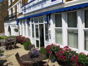 un restaurante con mesas y flores delante de él en The Burleigh, en Hunstanton