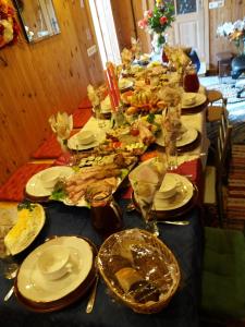 a long table with a blue table cloth with food on it at Eco Boutique Guest House Celmalas in Aglona