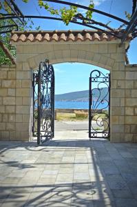 an entrance to a stone arch with two gates at Apartmani Mustur in Bijela