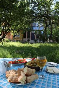 einen Tisch mit einem Teller Essen und einem Glas Wein in der Unterkunft Chateau Dio in Ambrolauri