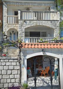 a house with a balcony and a patio at Apartmani Mustur in Bijela