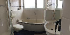 a bathroom with a tub and a toilet and a sink at Kellermanns Urlaubsdomizil in Einbeck +7 photos