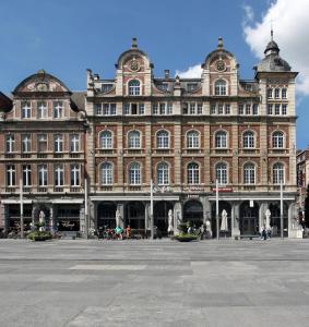een groot bakstenen gebouw met veel ramen bij Hotel La Royale in Leuven