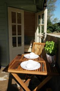 a wooden table with plates on it on a porch at Ashford house 'The Snug' private hot tub in Fylingthorpe +5 photos