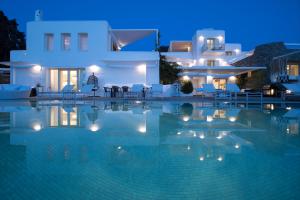 a villa with a swimming pool at night at Paros Butterfly Villas in Pounda