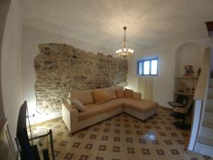 sala de estar con sofá y pared de piedra en SweetHome in Erice Vetta, en Erice