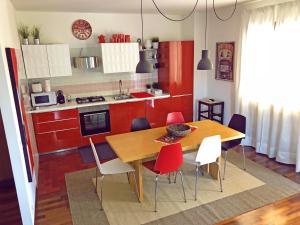 Farra di SoligoにあるLa Casa Di Beaのキッチン(木製テーブル、赤いキャビネット付)
