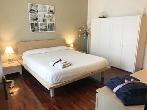 Farra di SoligoにあるLa Casa Di Beaのベッドルーム1室(大型ベッド1台、白いシーツ、荷物付)