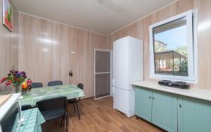 a kitchen with a table and a white refrigerator at Мини Отель Милый in Sanzhiyka +42 photos