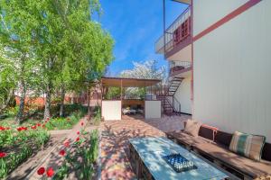 a patio with a couch and a table and flowers at Мини Отель Милый in Sanzhiyka