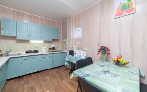 a kitchen with blue cabinets and a table with a table sidx sidx sidx at Мини Отель Милый in Sanzhiyka
