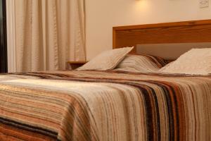 Una cama con una manta y almohadas encima en Annita Court Bock B, Apt3, en Ayia Napa 3 fotos más