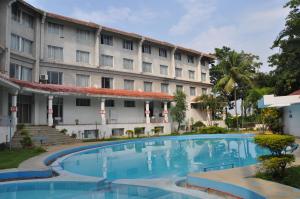 a hotel with a swimming pool in front of a building at Ramee Guestline Tirupati in Tirupati