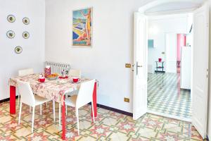 レヴァントにあるVia Dante Vacanze - Levantoのダイニングルーム(テーブル、白い椅子付)