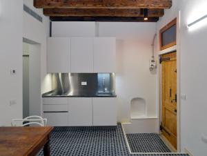 a kitchen with white cabinets and a wooden table at Carbonaia Venezia in Venice