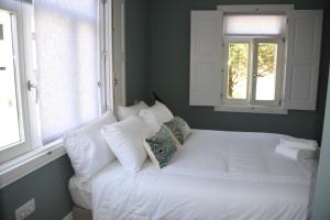 ポルトにあるPorto Traveler Apartmentの窓2つ付きの客室の白いベッド1台