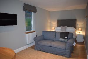 ein Wohnzimmer mit einem Sofa und einem Bett in der Unterkunft The Steading in Aberfeldy