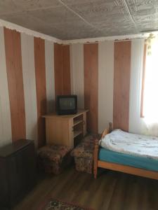 a small bedroom with a bed and a television at Edit Vendégház in Tiszaújváros