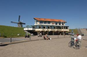 a group of people on bikes in front of a building at Hotel Havenzicht Texel in Oudeschild