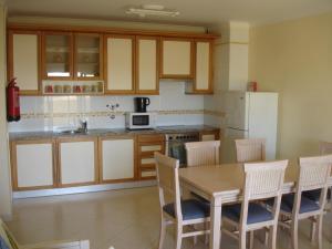 uma cozinha com uma mesa e cadeiras e um frigorífico em Vila Marachique 304 2 bedroom em Alvor