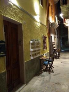 un callejón vacío con una mesa y sillas junto a un edificio en Carruggetto en Carloforte