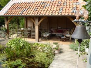 a garden with a gazebo with a horse on the roof at De Epicurist in Hasselt