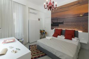 a bedroom with a bed with red pillows and a chandelier at B&B MARSALA in Marsala
