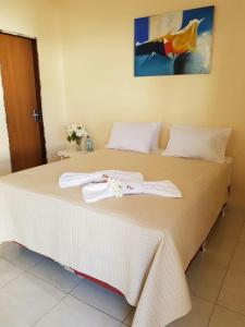 a large bed with two white towels on it at Vila Maria Pousada in São Miguel do Gostoso