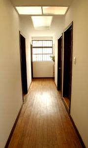 an empty hallway with wood floors and a window at Magdalena Guest House in Bogotá