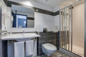 ein Bad mit einem Waschbecken, einem WC und einer Dusche in der Unterkunft Le Lodge de Sologne in Vierzon