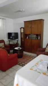 a living room with a red couch and a tv at Casa Reis in Santana