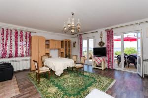 a living room with a table and chairs and a television at Apartments and Room Luka in Klenovica