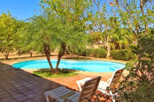a swimming pool with two chairs and a palm tree at Casa Dror Gran Pacifica Resort in San Diego