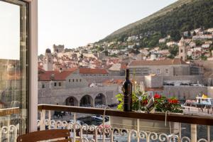 a bottle of wine on a balcony with a view of a city at Apartment CATIVLA in Dubrovnik