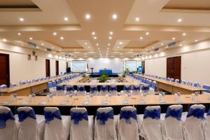 a large banquet hall with long tables and chairs at Vila Ombak in Gili Trawangan