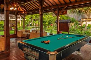 a pool table in a room with a patio at Vila Ombak in Gili Trawangan