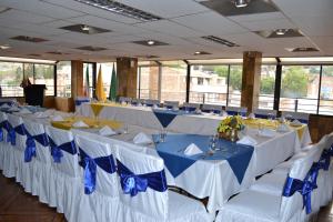 ein Raum mit Reihen von Tischen mit blau-weißen Stühlen in der Unterkunft Hotel Oicatá in Duitama + 54 Fotos