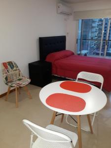 1 dormitorio con 1 cama, mesa y sillas en Bajada Sargento Cabral en Rosario